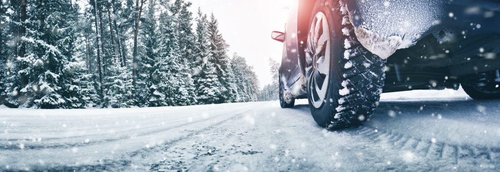 Auto v zasněžené zimní krajině na celoročních pneumatikách
