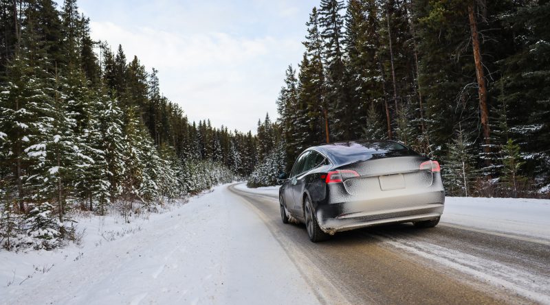 Automobil Tesla projíždějící zimní krajinou