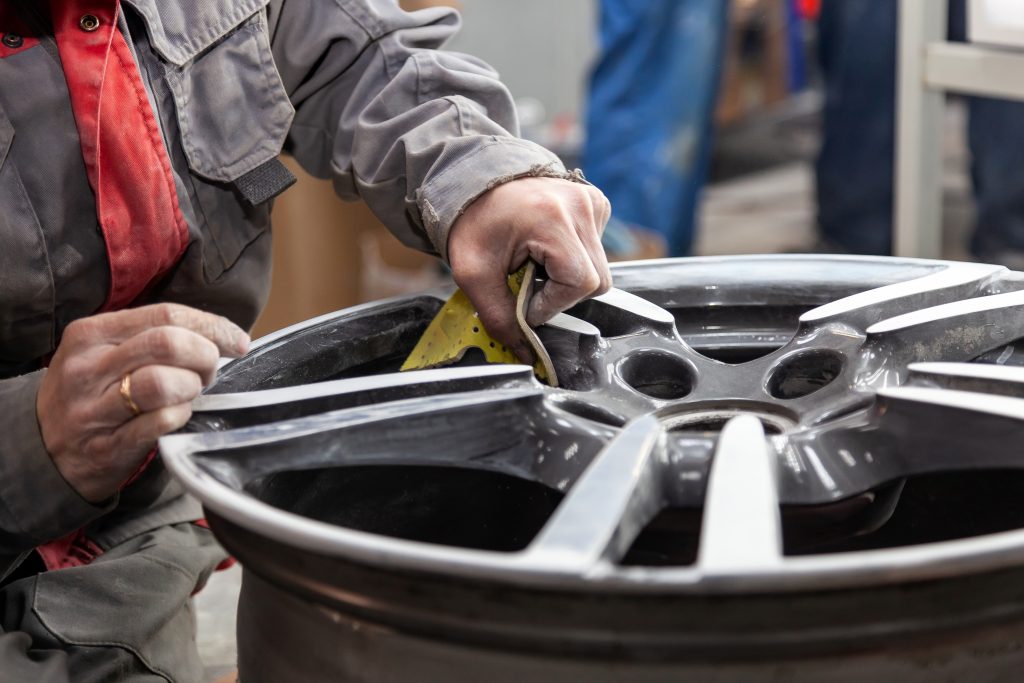 Automechanik opravuje disk z osobního vozidla
